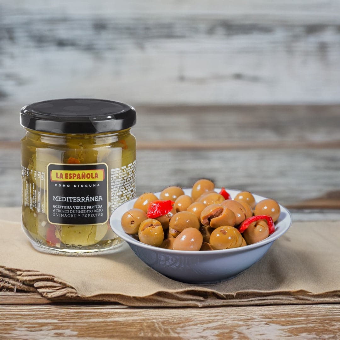 a jar of olives and a bowl with green olives