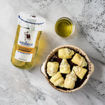 a jar of artichokes and a bowl with artichokes