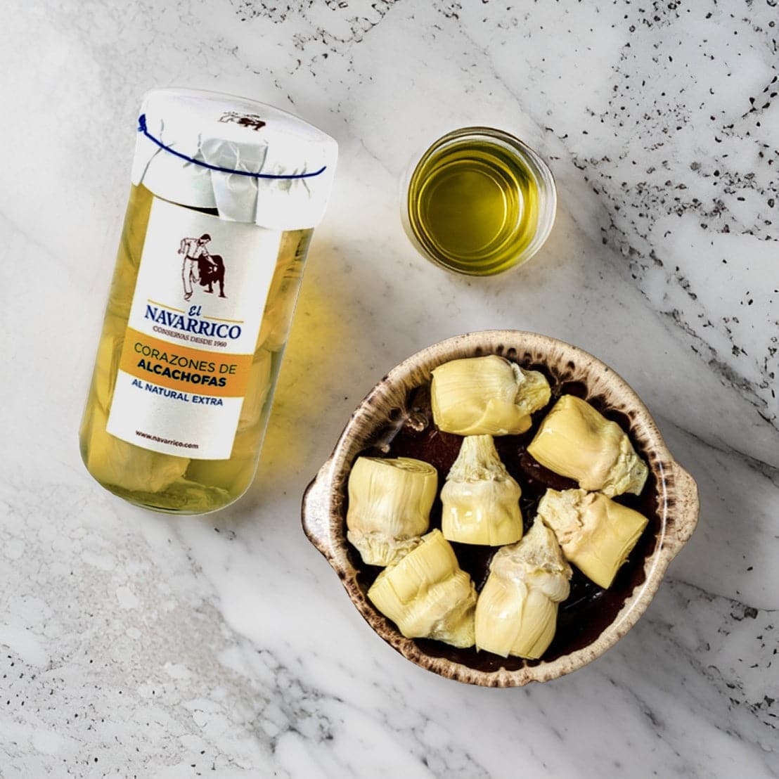a jar of artichokes and a bowl with artichokes